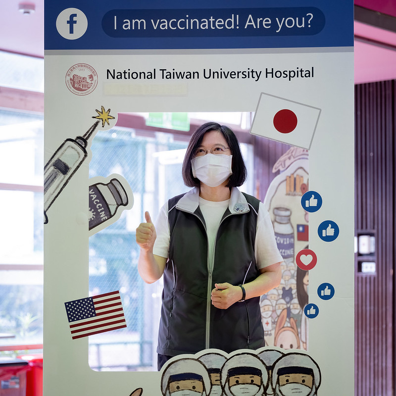 總統領取臺大醫院疫苗接種紀念貼紙，並於打卡板合影留念